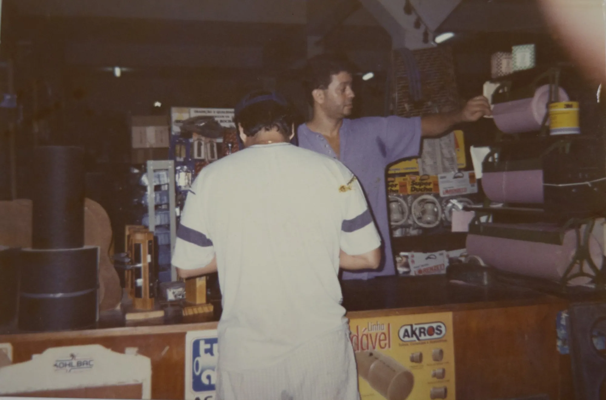 Atendimento no balcão, em foto antiga da loja.