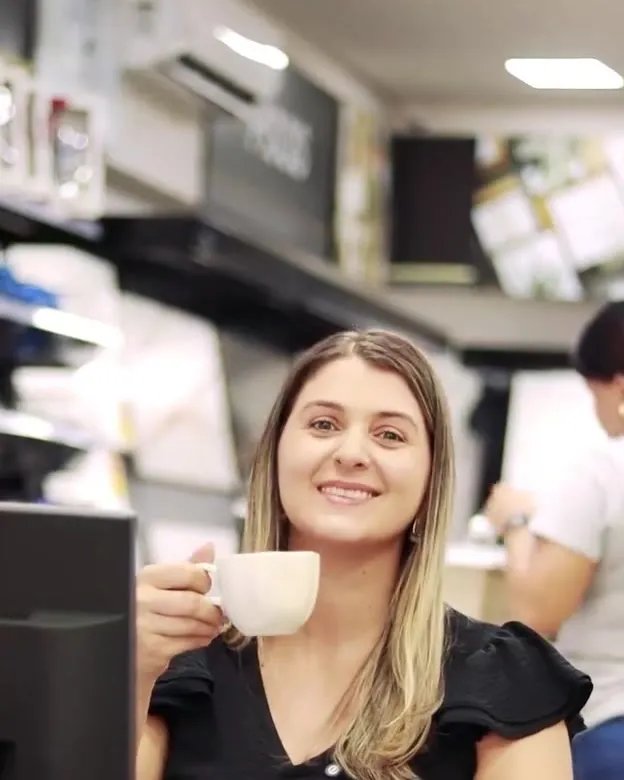 Vanessa sorrindo com uma xícara de café na Eletromário Acabamentos